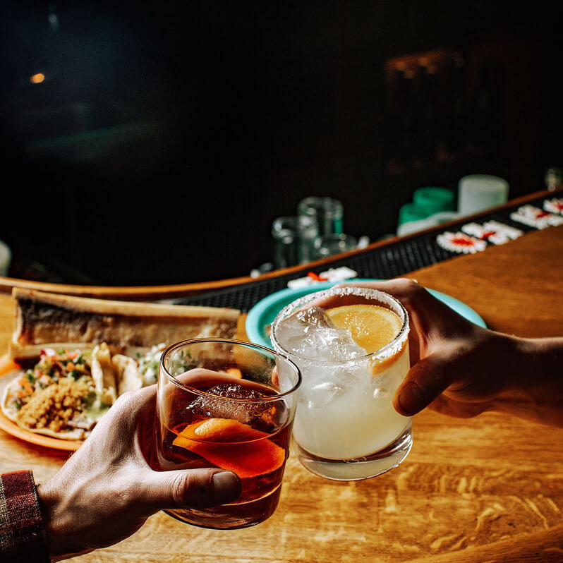 Toasting with a margarita and cocktail.